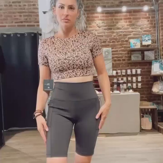 WEAR LOVE MORE Designer Sustainable Activewear Audrey Reversible Short Sleeve Longline Crop Bra in Nude Leopard.   Recycled Luxury Performance Fabric in Nude Leopard.  Show as styled at Bergen Point Boutique in Video
