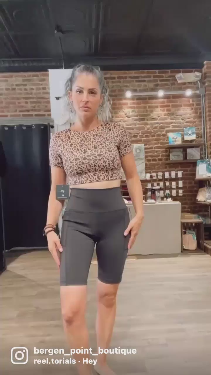 WEAR LOVE MORE Designer Sustainable Activewear Audrey Reversible Short Sleeve Longline Crop Bra in Nude Leopard.   Recycled Luxury Performance Fabric in Nude Leopard.  Show as styled at Bergen Point Boutique in Video